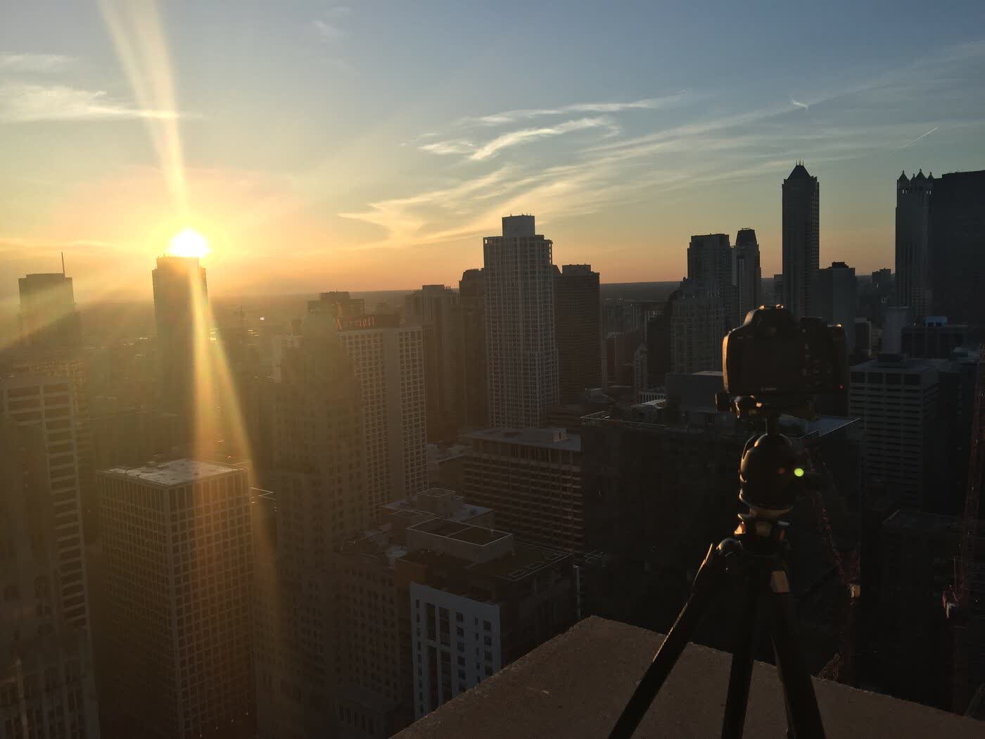 Camera on a rooftop overlooking the Chicago skyline at sunset